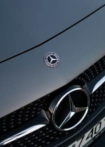silver mercedes benz emblem on gray car